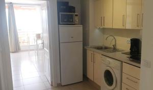 uma cozinha com uma máquina de lavar roupa e um micro-ondas em Seaview apartment near the beach em Playa de las Americas