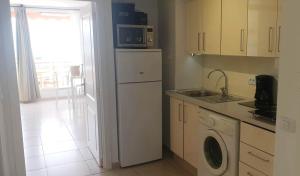 een keuken met een wasmachine en een magnetron bij Seaview apartment near the beach in Playa de las Americas