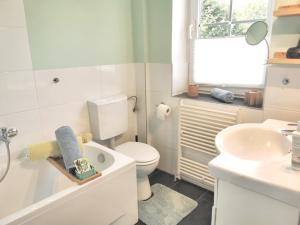 a white bathroom with a toilet and a sink at Gästehaus "Duvenstedter Brook" 