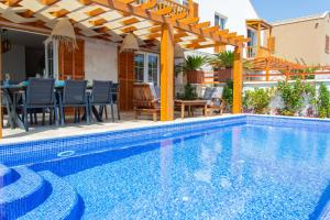 a swimming pool with a pergola next to a house at Villa Blue, LaVanta, Kalkan in Kalkan +11 photos