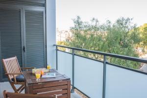 a balcony with a table and two glasses of orange juice at Hauzify I Apartaments Coral in Torredembarra