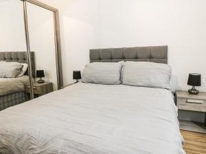 a bedroom with a large bed and a mirror at Heatherbank in Garelochhead