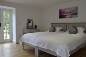 a bedroom with a white bed with two pillows at Smithy House in Forfar