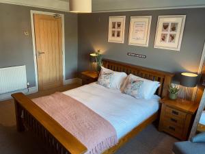 1 dormitorio con 1 cama grande con sábanas y almohadas blancas en The Riverside Rooms en Newark upon Trent
