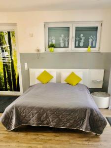 a bedroom with a bed with two yellow pillows at Apartment Oase- Kaiserslautern in Kaiserslautern