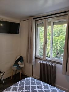 1 dormitorio con cama, ventana y silla en hotel de la gare en Modane