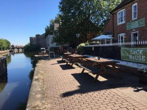 a row of picnic tables next to a river at The Riverside Rooms in Newark-on-Trent