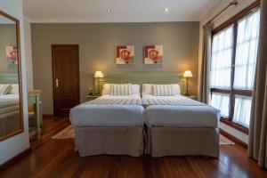 a large bedroom with two beds and two windows at Laguna Nivaria Hotel & Spa in La Laguna