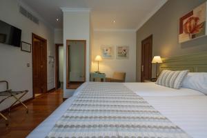 um quarto com uma grande cama branca num quarto em Laguna Nivaria Hotel & Spa em San Cristóbal de La Laguna
