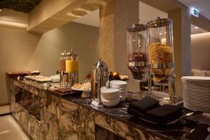 a buffet with plates and food on a table at OMID Saldanha Hotel in Lisbon
