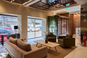 a lobby with a couch and two chairs and a table at OMID Saldanha Hotel in Lisbon