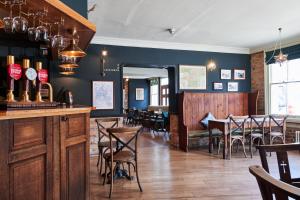 a restaurant with a bar and tables and chairs at The Kings Arms in Woodstock