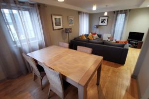 uma sala de estar com uma mesa de madeira e um sofá em Bright Modern Apartment - Royal Mile em Edimburgo