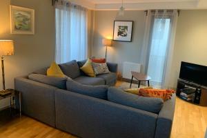 ein Wohnzimmer mit einem blauen Sofa und einem TV in der Unterkunft Bright Modern Apartment - Royal Mile in Edinburgh