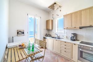 a kitchen with a table with a bowl of fruit on it at IRIDA Villa - Sea & Sunset Flats by Explore Andros in Batsi +20 photos