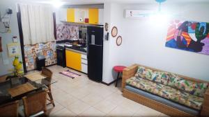 a living room with a couch and a kitchen at Solar de Pipa Duplex Flat in Pipa