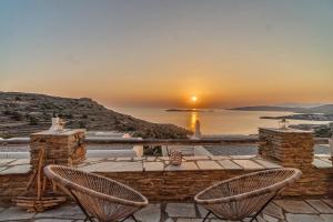 una vista sul tramonto da un patio con due sedie di IRIDA Villa - Sea & Sunset Flats near Batsi a Mpatsi (Batsi)