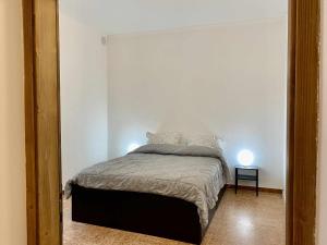 1 dormitorio con 1 cama en una pared blanca en Casa Il Geranio Tenna OSPITAR, en Tenna 