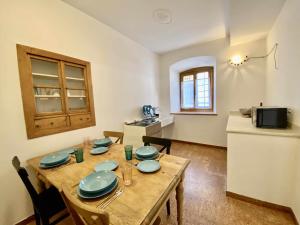 una cocina con una mesa de madera con placas azules. en Casa Il Geranio Tenna OSPITAR, en Tenna 