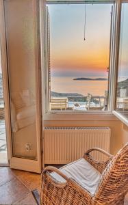 um quarto com uma janela e uma cadeira de vime em IRIDA Villa - Sea & Sunset Flats near Batsi em Batsi