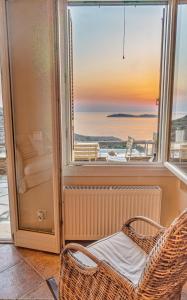 a room with a window and a rattan chair at IRIDA Villa - Sea & Sunset Flats by Explore Andros in Batsi