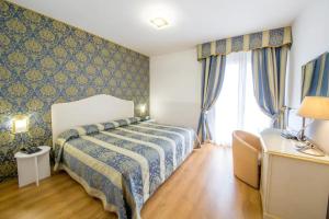 a bedroom with a bed in a room with a window at LAERTE PALACE HOTEL in Mogliano Veneto