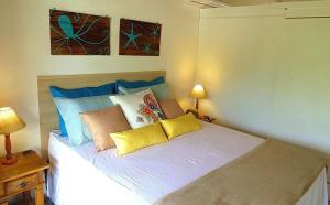a bed with colorful pillows on it in a room at Solar Agua Flats Elegance Flat in Pipa