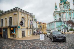 a city street with cars parked on a cobblestone at MOONOTEL Maidan in Kyiv