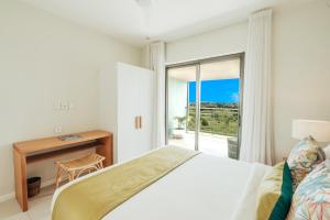 a bedroom with a bed and a desk and a window at Domaine de Grand Baie in Grand-Baie +36 photos