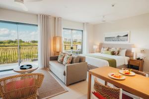 a hotel room with a bed and a couch at Domaine de Grand Baie in Grand-Baie