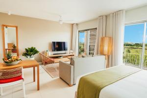 a bedroom with a bed and a living room at Domaine de Grand Baie in Grand-Baie