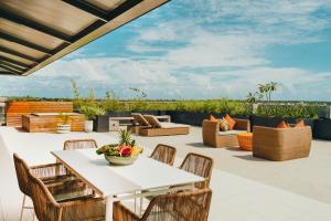 an outdoor patio with a white table and chairs at Domaine de Grand Baie in Grand-Baie