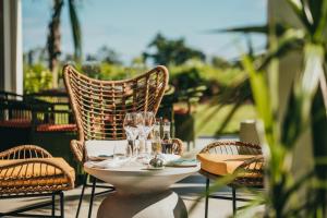 a table with glasses and chairs on a patio at Domaine de Grand Baie in Grand-Baie