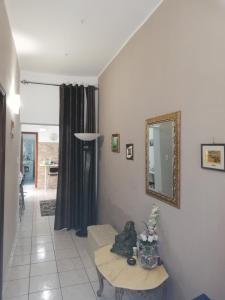 ein Wohnzimmer mit einem Spiegel und einem Tisch in der Unterkunft Catania House in Catania