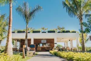 a building with palm trees in front of it at Domaine de Grand Baie in Grand-Baie