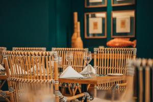 a wooden table with chairs and wine glasses at Domaine de Grand Baie in Grand-Baie