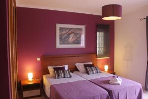 a bedroom with two beds with purple walls at Casa Dos Cedros in Lagos +67 photos