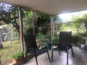zwei Stühle auf einer Veranda im Garten in der Unterkunft Lux-2-or-1- persons Irodion Edoshvili Street #15 in Kutaissi