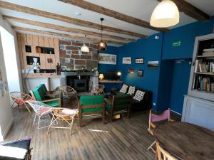 a living room with blue walls and a table and chairs at La Maison - Hôtel & Gîte in Laguiole