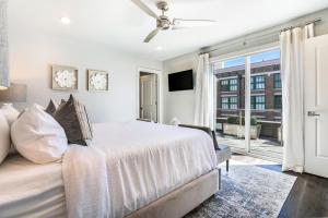 a white bedroom with a bed and a window at The Port in New Orleans