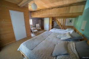 1 dormitorio con 2 camas en una habitación con paredes de madera en Chambre d'hotes La Source Aveyron, en Saint-André-de-Najac