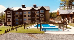 a large apartment building with a pool and a playground at Depto Pucon WIFI Internet full equipado a 2 min de lago y centro in Pucón