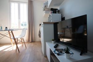 A television and/or entertainment centre at Home2Stay Valognes