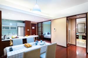 a kitchen and living room with a table and chairs at Tianjin Crown International Apartment in Tianjin