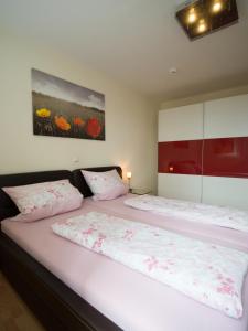 1 dormitorio con 2 camas con sábanas rosas en Ferienwohnung Fernblick en Saarbrücken