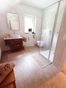 a bathroom with a shower and a sink and a toilet at Apartments Zwigl in Flattach