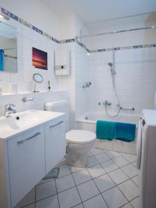 ein weißes Badezimmer mit einem WC-Waschbecken und einer Badewanne in der Unterkunft Ferienwohnung Fernblick in Saarbrücken