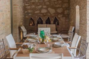 mesa de madera con sillas blancas y comedor en Villa Sabrina 12 en Cagli