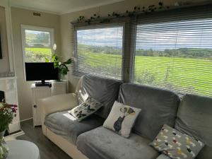 a living room with a gray couch with pillows at Farm stay property Pets and families welcome in Rossnowlagh