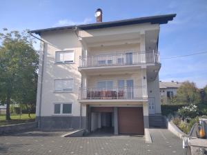 a large white building with a balcony and a garage at Kuća za odmor Dugo Selo M&A in Dugo Selo